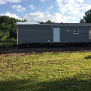 Mobile home safely transported and placed on leveled ground.